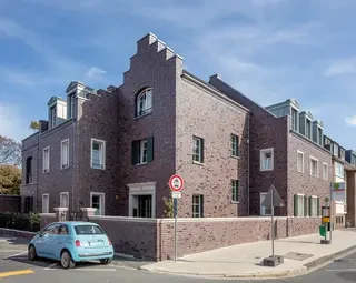 Eckansicht der Backstein-Stadtvilla in Düsseldorf mit Stufengiebel und klassischer Fassadenstruktur