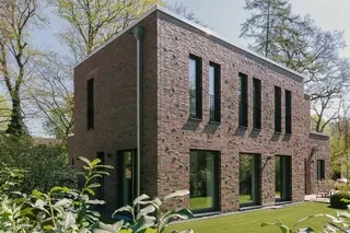 Zweigeschossiges Klinkerhaus in Hamburg mit schmalen Obergeschossfenstern, großen Gartenfenstern und rotbunter Klinkerfassade in Sortierung 68 DF