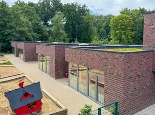 Kindergartengebäude mit rotbunter Klinkerfassade und Flachdach