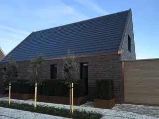 Modernes Einfamilienhaus mit dunkler Langformat-Klinkerfassade und anthrazitfarbenem Satteldach im Westmünsterland.“