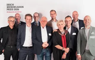 Gruppenfoto vor einer weißen Wand mit dem Logo Erich Mendelsohn Preis 2026