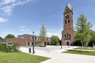 Pfarrhaus mit Klinkerfassade vor Kirche in Lütgendortmund
