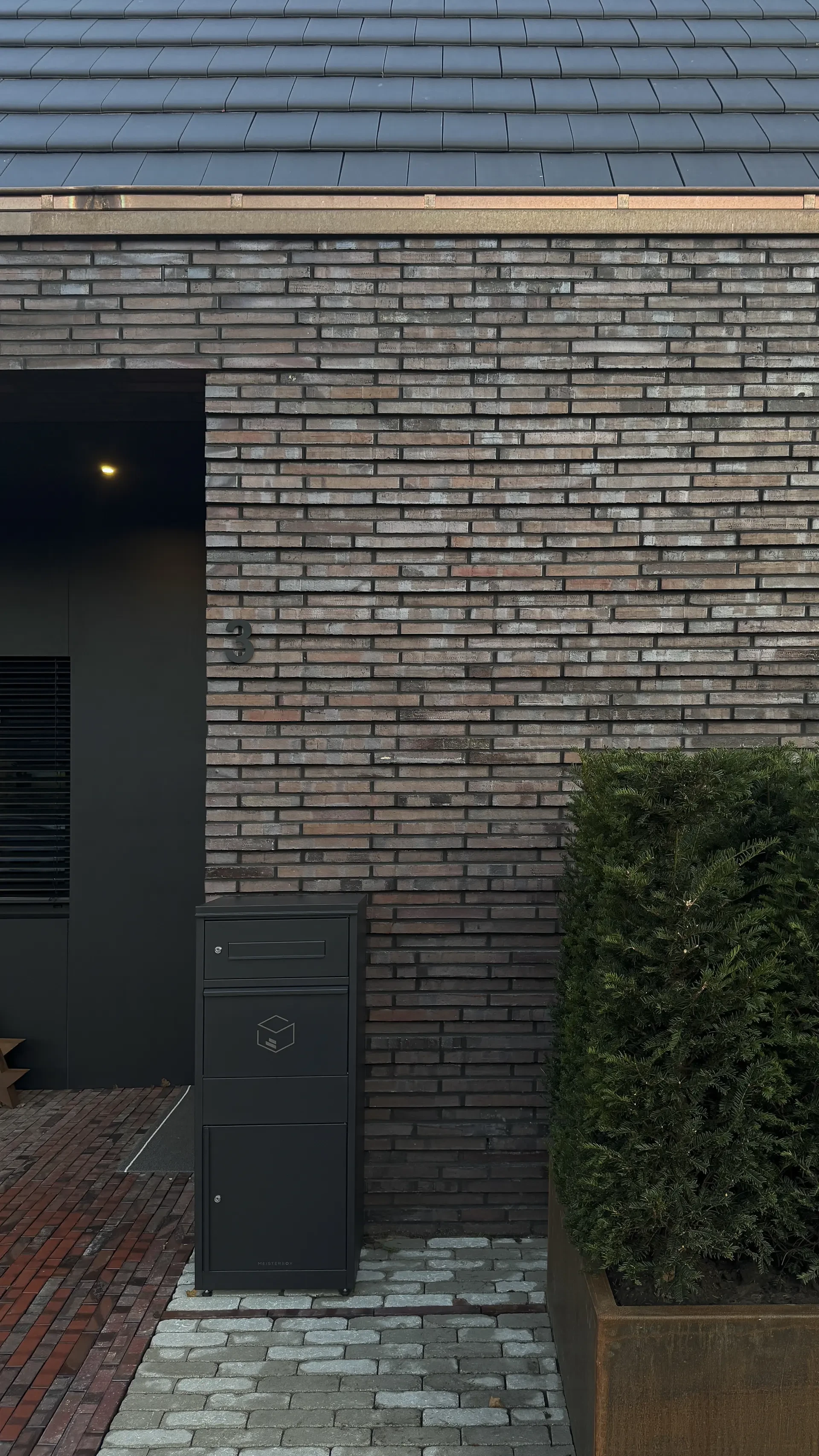 Detail des Eingangsbereichs eines modernen Einfamilienhauses mit dunkler Langformat-Klinkerfassade