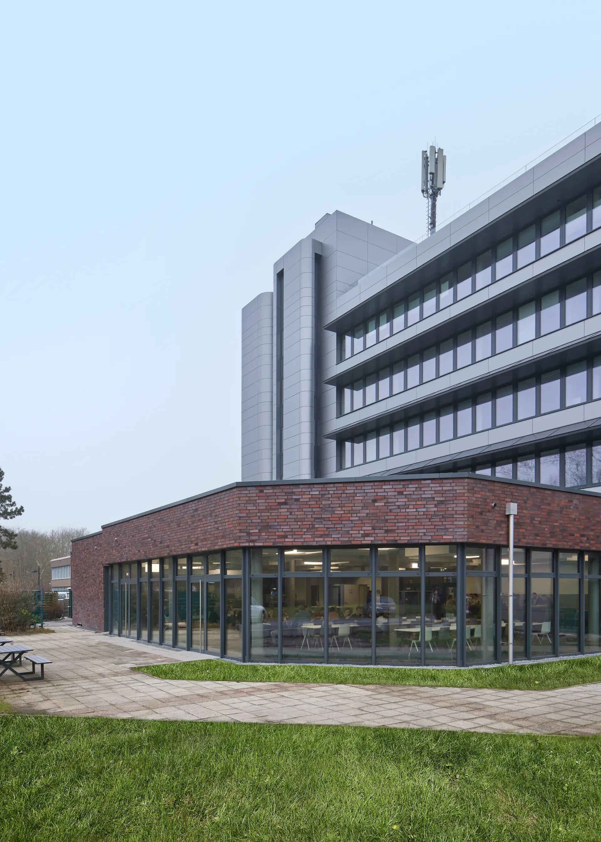 Seitenansicht des Bildungszentrums Dortmund mit Klinkersockel aus Wittmunder Klinker 131.1 und gläserner Rundung im Erdgeschoss